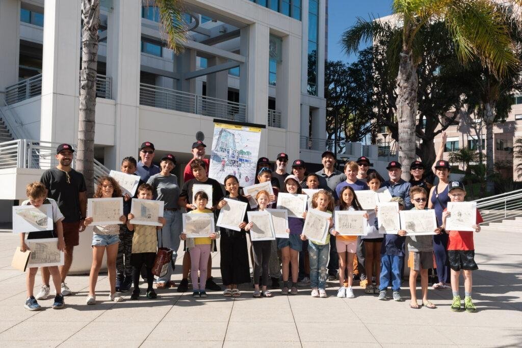 Children sketching buildings at a Kids Draw Architecture event